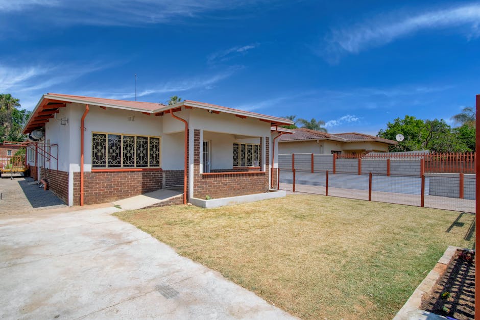 A house with a fence and grass in front of it