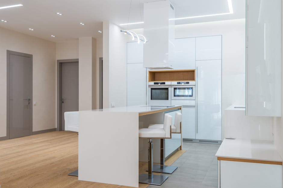 Interior of empty spacious kitchen with new white furniture in contemporary apartment with minimalistic design
