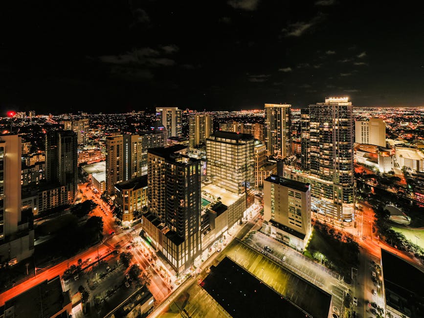 Drone view of illuminated glass skyscrapers in financial district of Fort Lauderdale against night sky