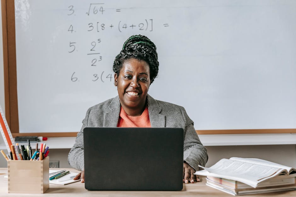 Positive black woman with laptop smiling in classroom