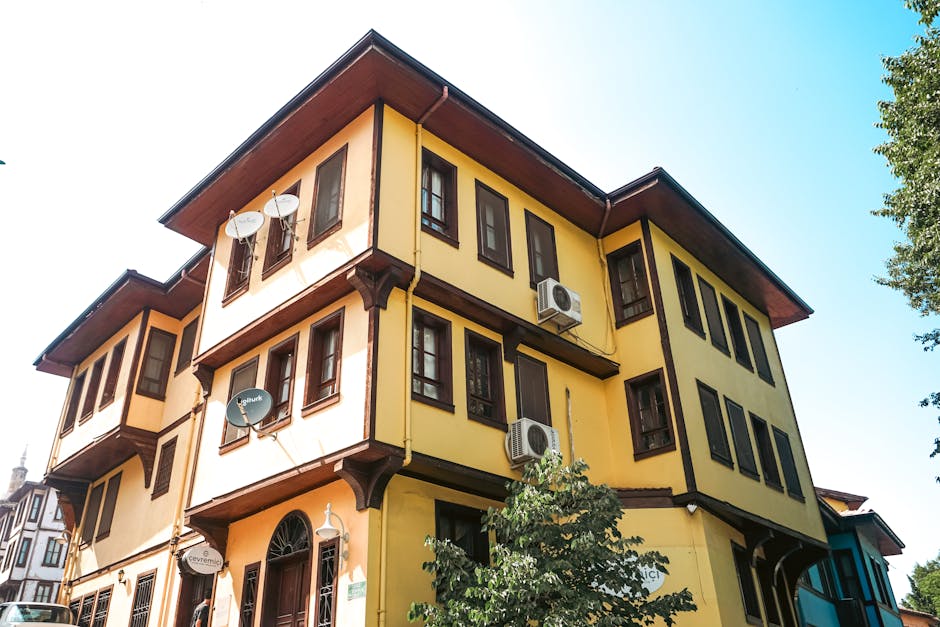 A yellow building with windows and balconies