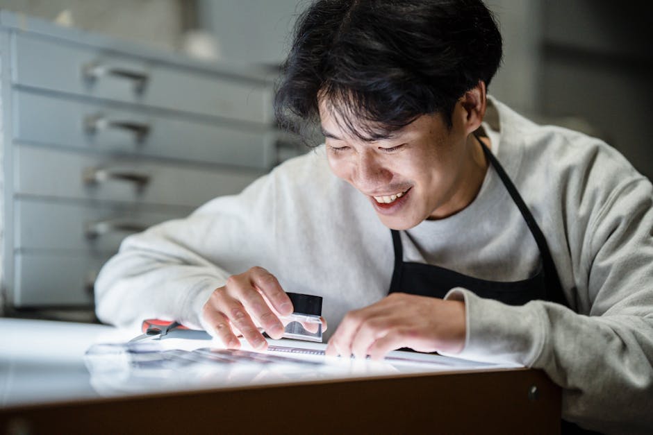 Smiling Photographer Watching Negatives Under Magnifying Glass