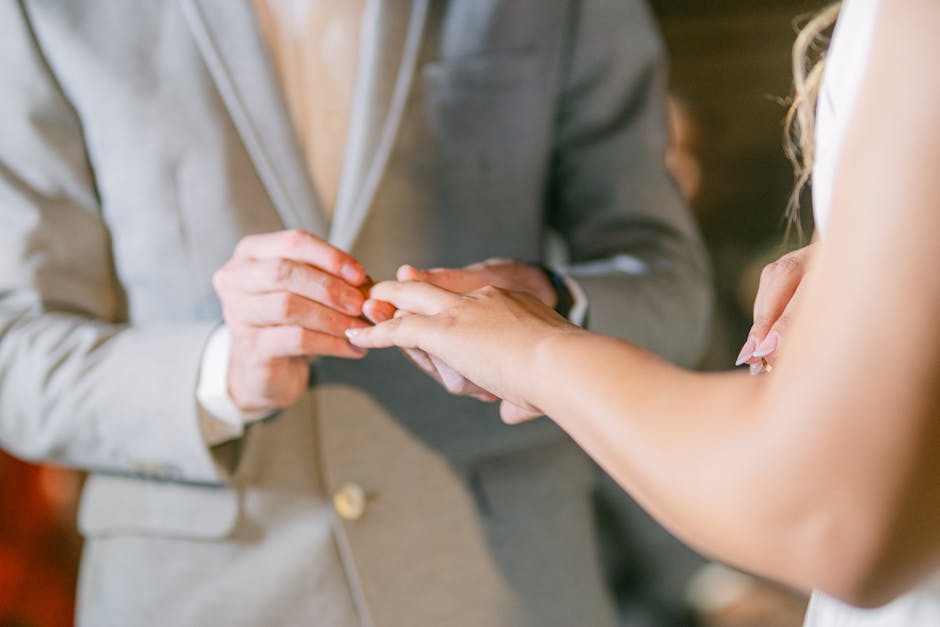 A man and woman are putting their wedding rings on each other