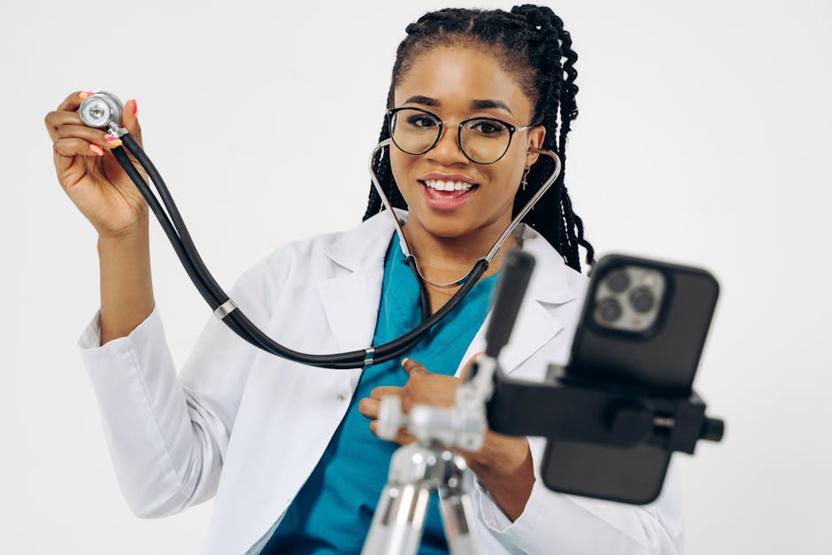 Smiling Black Doctor with Dreadlocks Recording Video on Cellphone