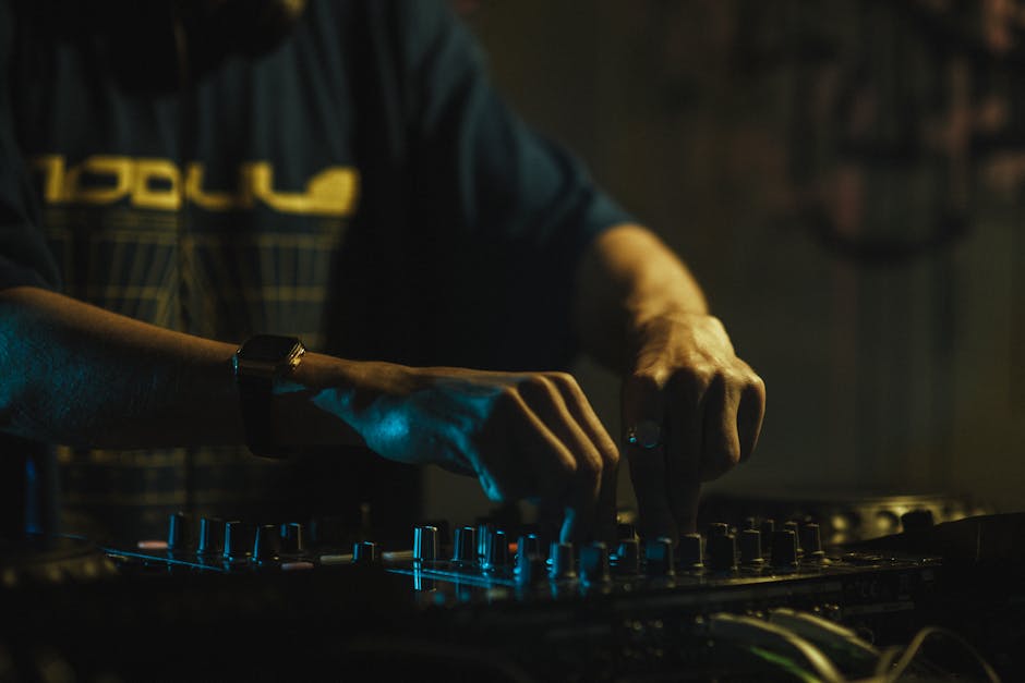 Close-up of a DJ Mixing Music on a Console in a Nightclub