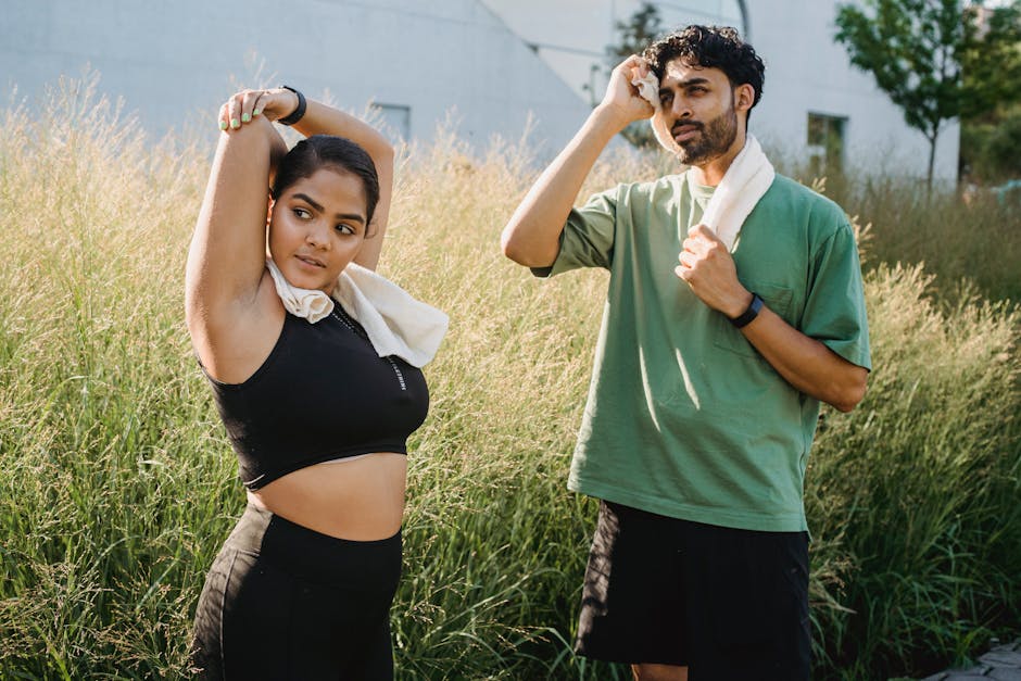 Woman and Man Stretching after Exercising Outdoors