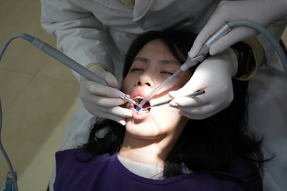 A woman getting her teeth cleaned by a dentist