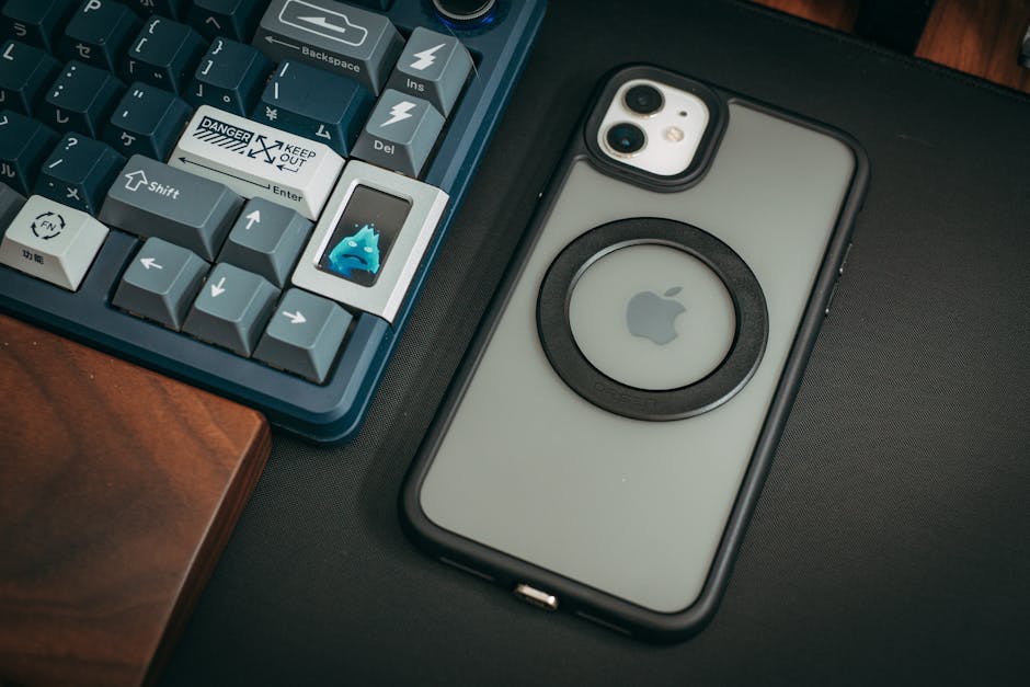 A phone case with a black ring on it sits next to a keyboard