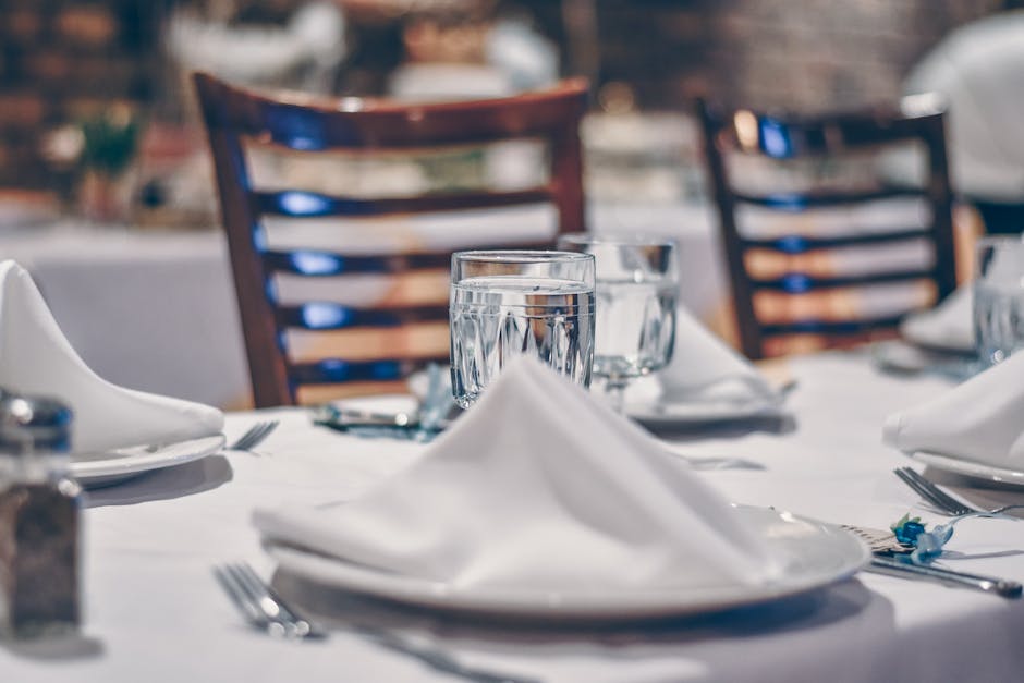 Depth of Field Photo of Clear Drinking Glass on White Table Near Plate