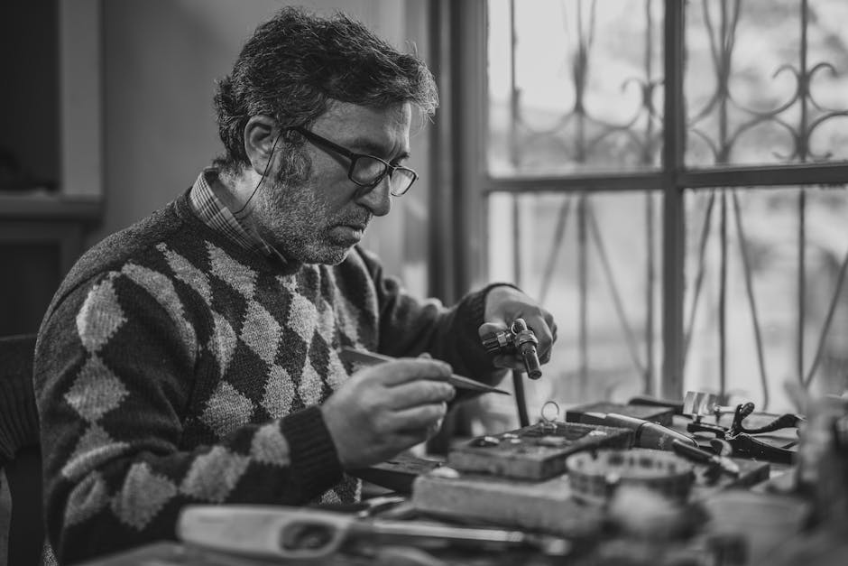 Grayscale Photo of Man Holding Tools