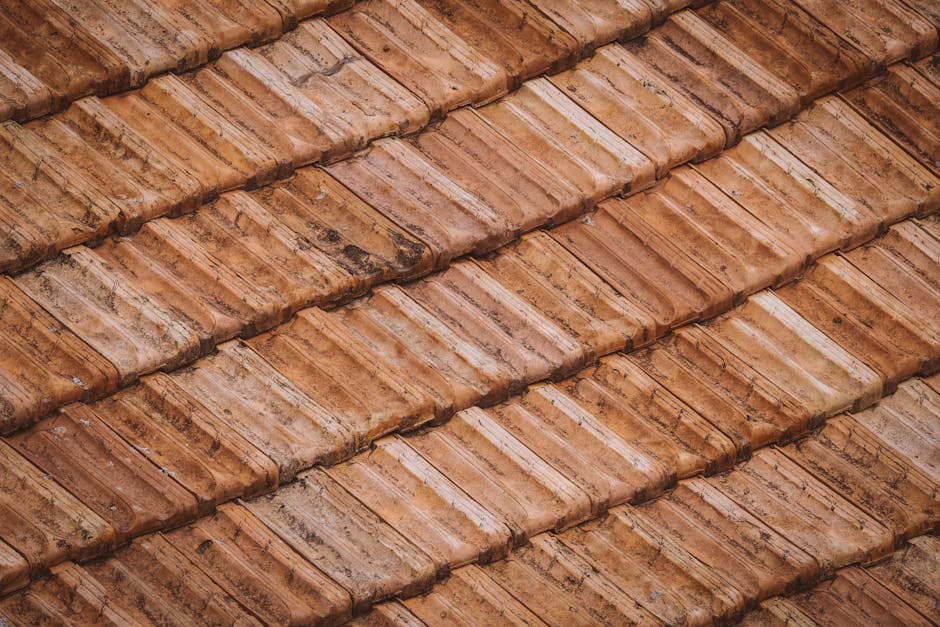 From above of grunge weathered textured surface of roof tiles of aged building