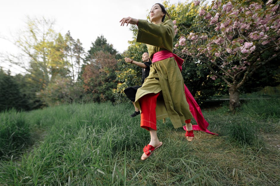 Girl in Green and Red Dress Standing on Green Grass Field