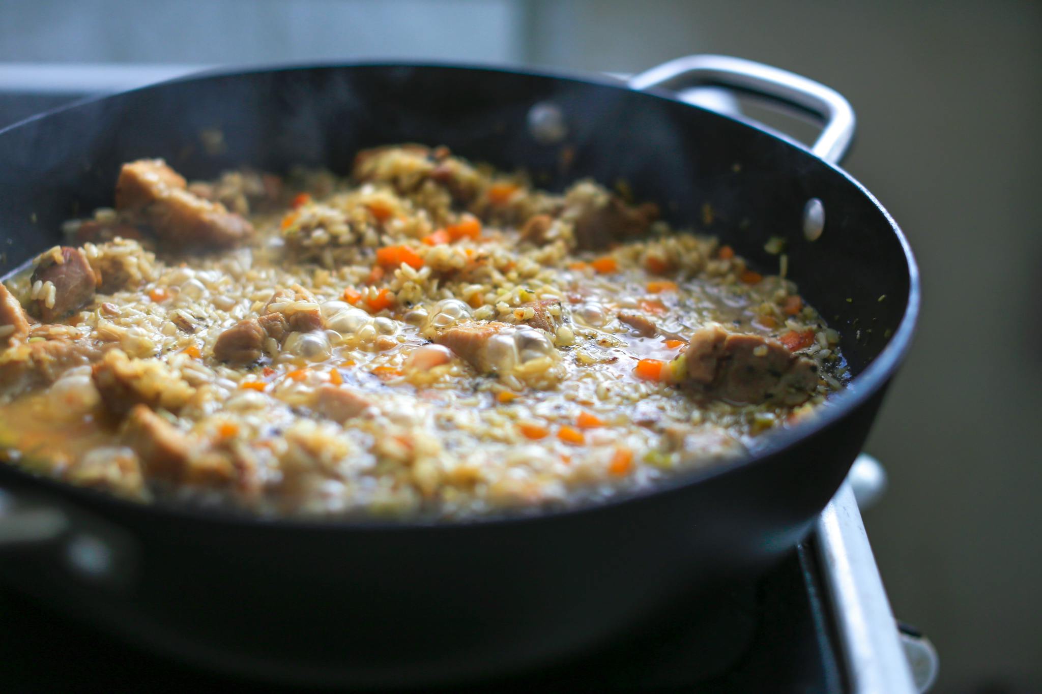 brown rice with veggies & boneless pork ribs in a cast iron pan