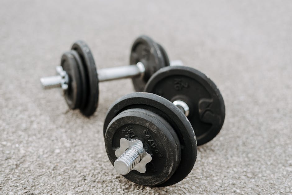 Heavy iron dumbbells placed on asphalt road