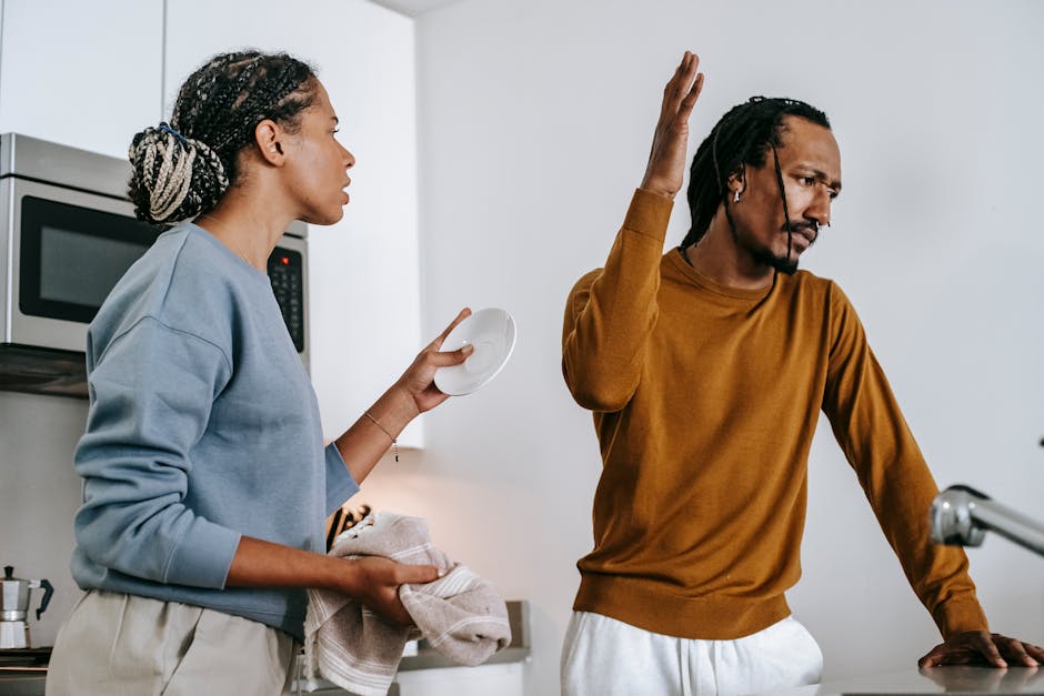 Discontented black couple arguing in kitchen at home