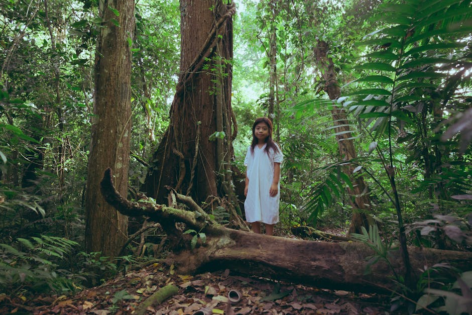 Photo Of Young Girl Standing Behind Tree Trunk