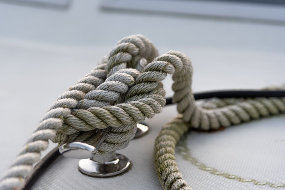 Closeup of strong mooring rope tied around steel anchor with nautical knot on modern yacht