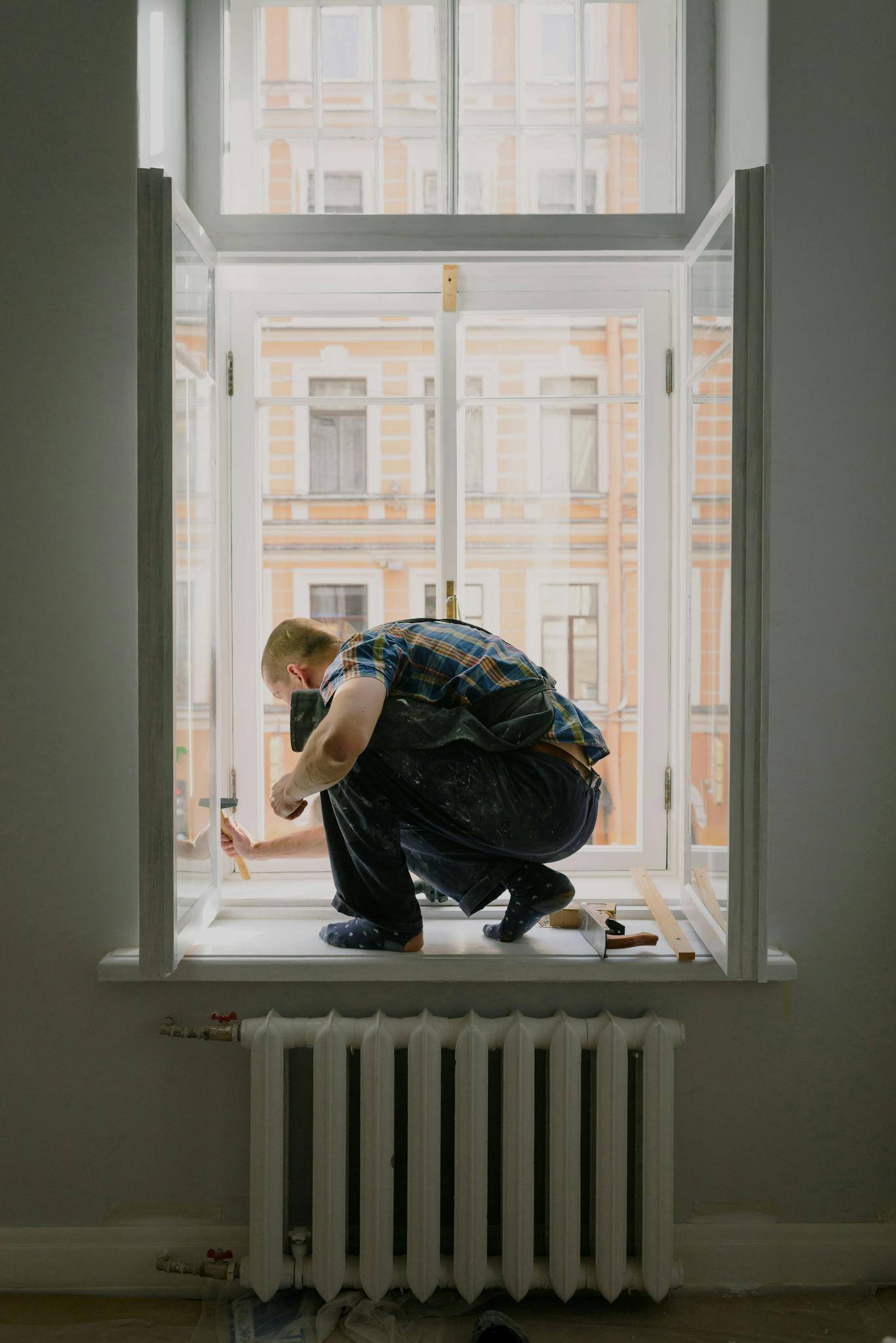 Anonymous man on windowsill during repair work