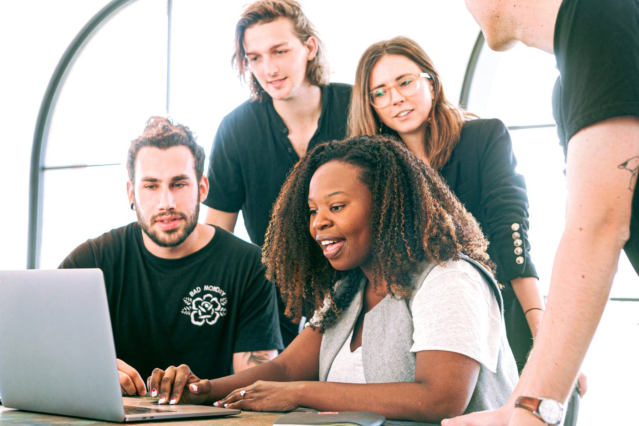 Cheerful diverse colleagues joining hands after coming to agreement