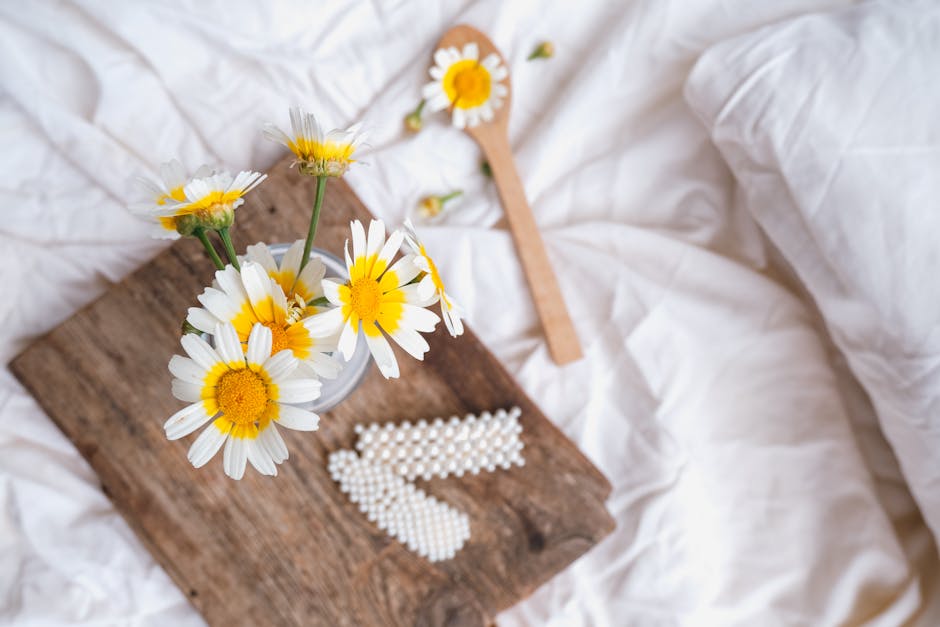 A wooden spoon and daisies on a bed