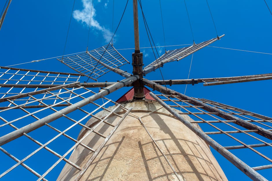 The top of a windmill with a blue sky in the background