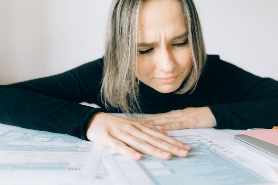 Woman in Black Long Sleeve Shirt Looking at Tax Forms