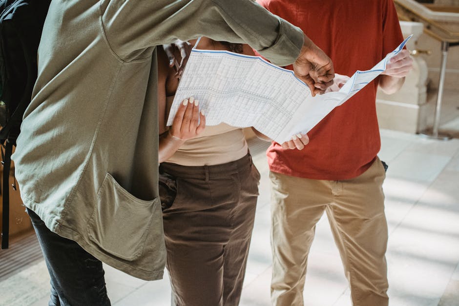 Anonymous diverse tourists exploring map during trip