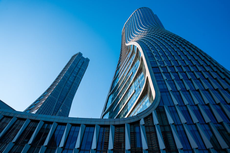 Two tall buildings with curved glass windows