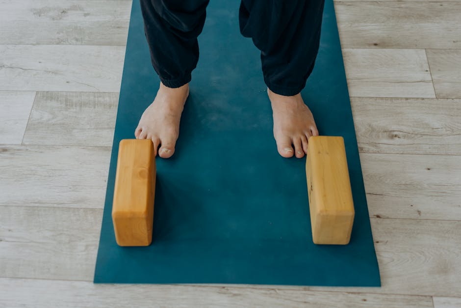 A Person Standing on Blue Yoga Mat with a Pair of Yoga Blocks