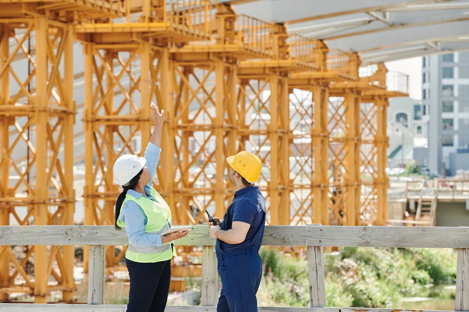 A Man and a Woman with Ppe’s Talking at a Construction Site