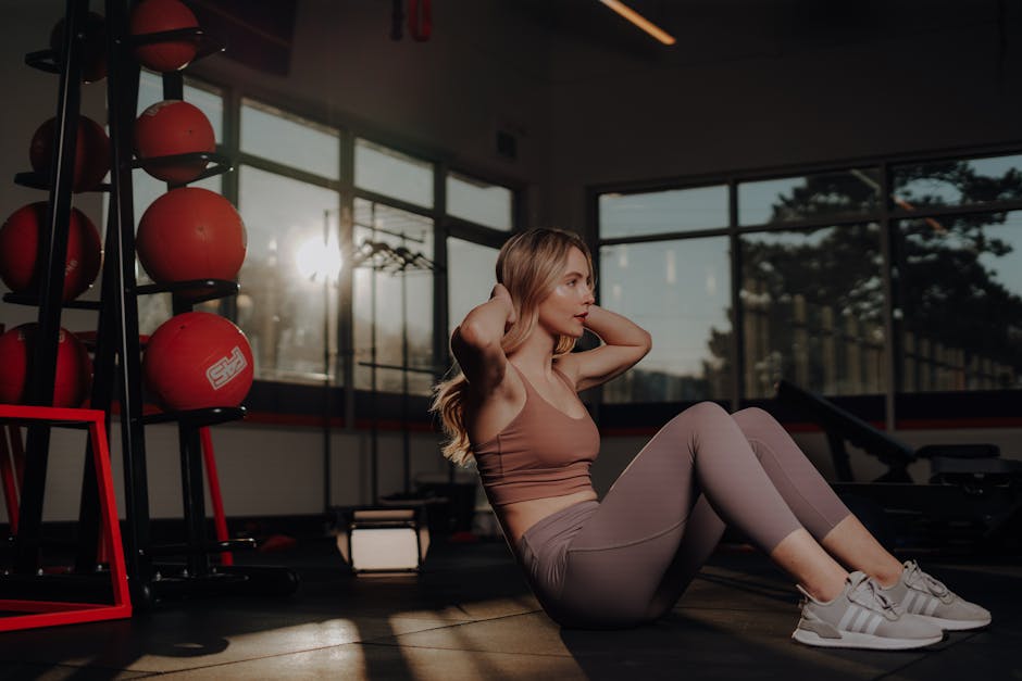 A woman is doing sit ups in a gym