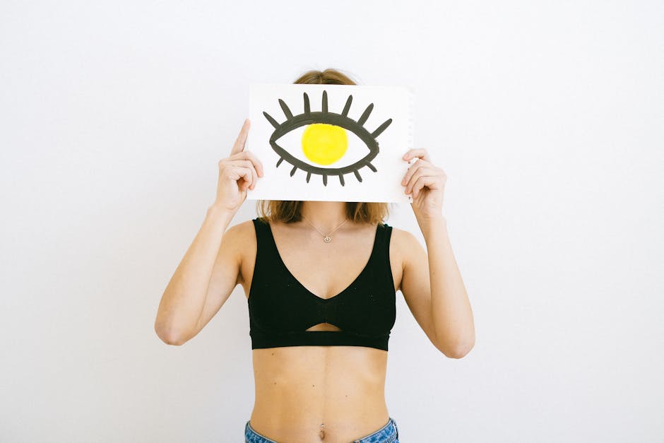 Woman Wearing a Bra, Holding a Paper with an Eye Drawing