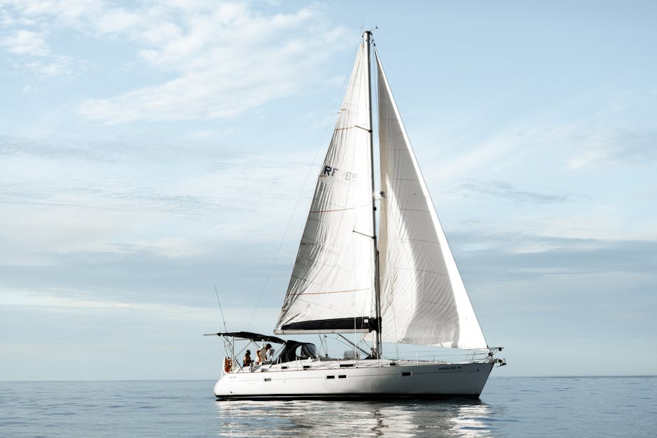 A Sailboat Floating on the Sea Under white Clouds