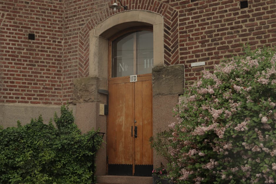 A door is open in front of a brick building