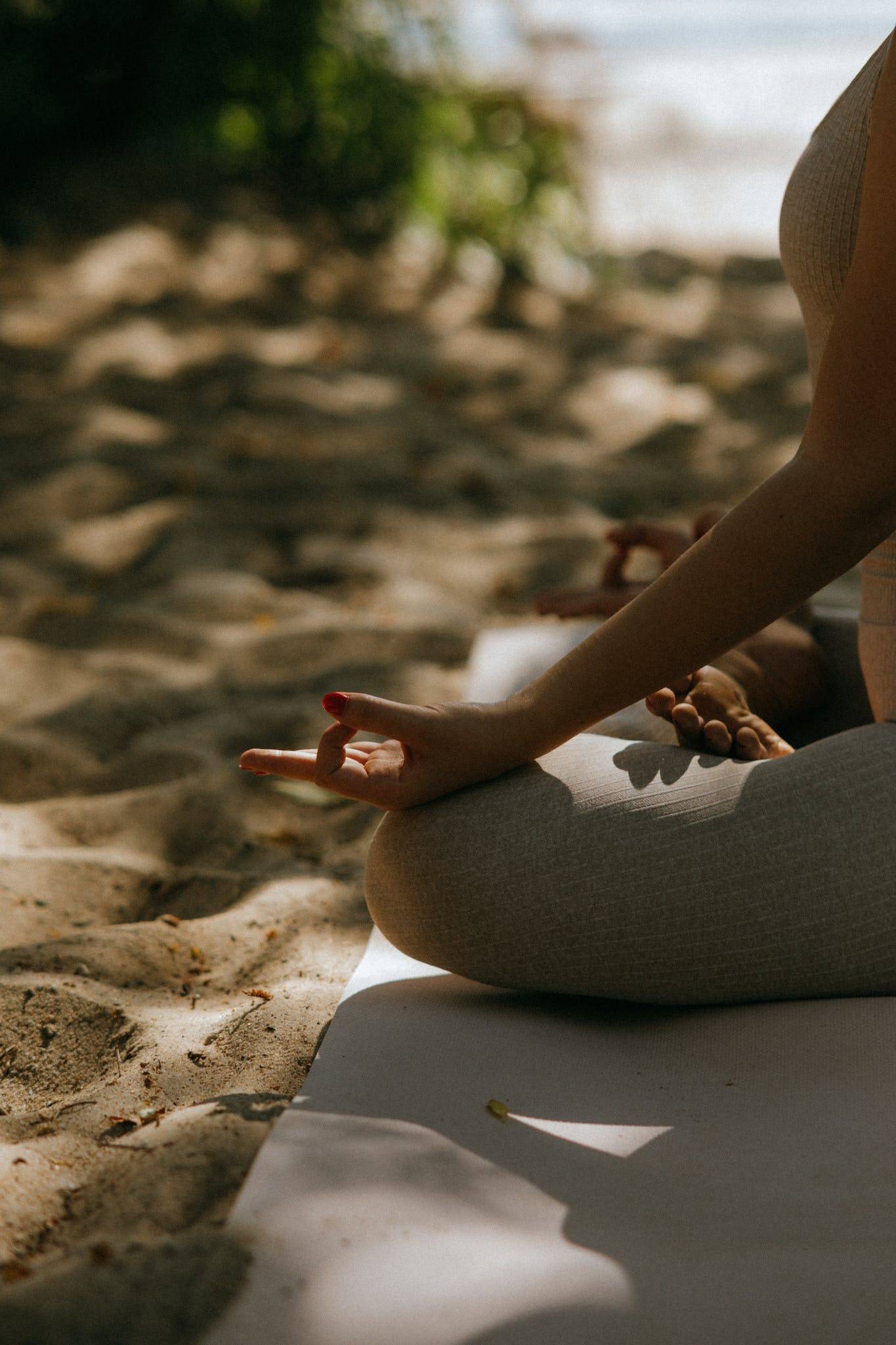 Close-up Shot of a Person Sitting on a Yoga Mat while Meditating