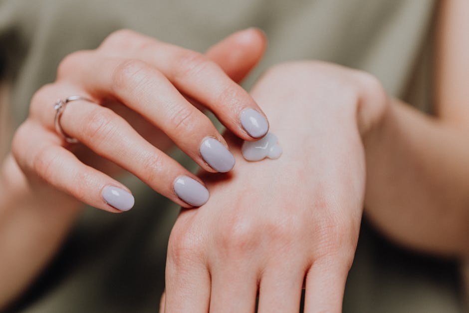 Crop woman with ring applying hand cream