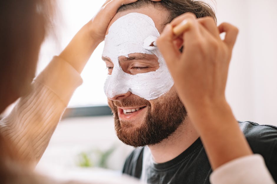 Person Applying Facial Cream to a Bearded Man