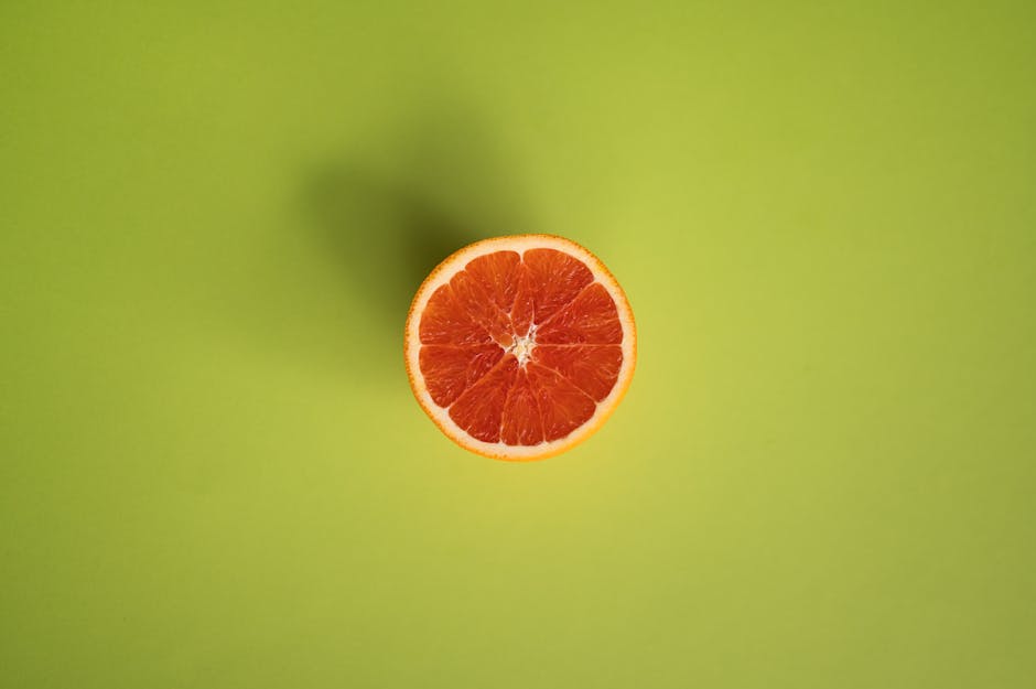Slice of grapefruit on green surface