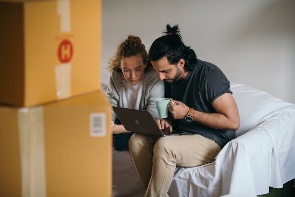 Young multiethnic couple watching laptop while moving house
