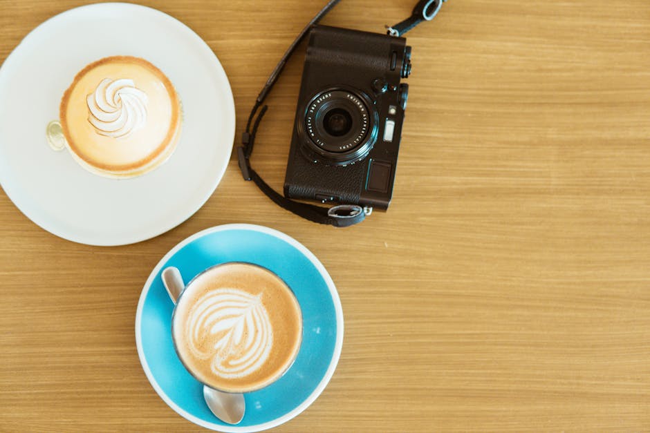 Black Camera And Two Coffee Cups With Saucers