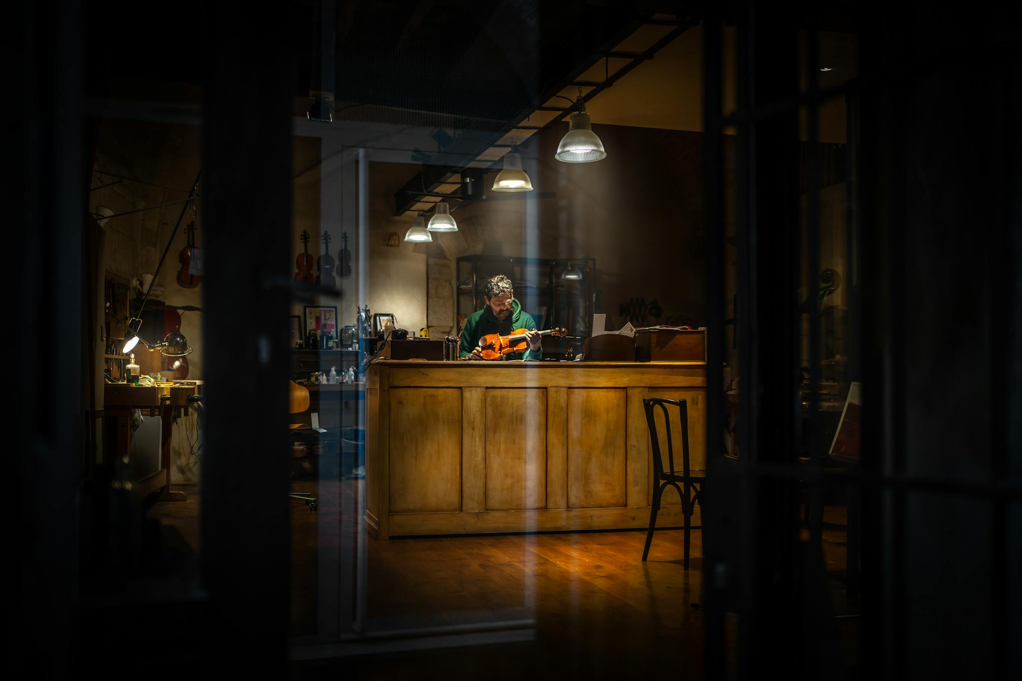 Wide Angle Shot of a Man Repairing His Violin