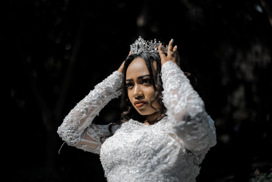 Concentrated ethnic woman in wedding dress and crown before ceremony