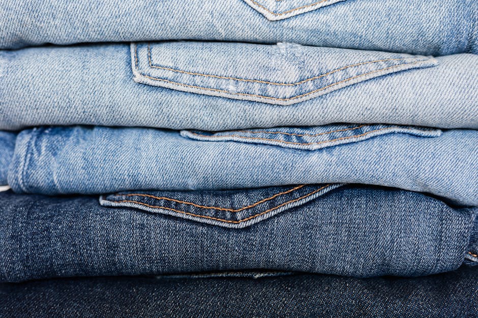 Closeup of stack of blue denim pants neatly arranged according to color from lightest to darkest