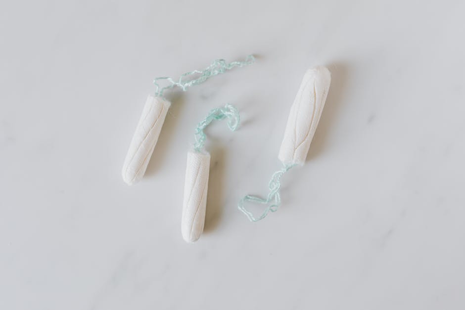 Menstrual Health Education ; Top view of three hygienic cotton tampons placed on white marble patterned surface