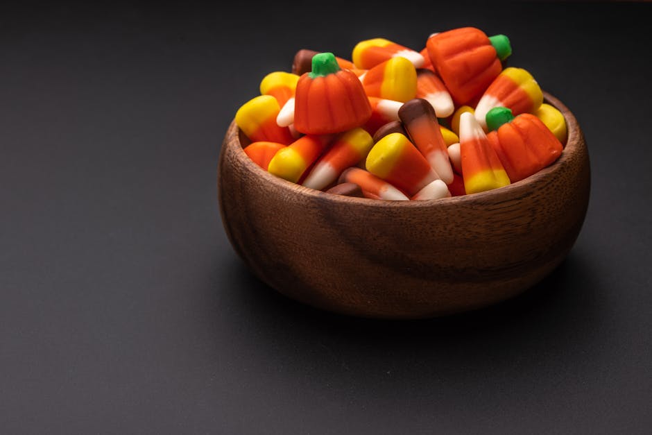 Bowl with yummy colorful gummies on table