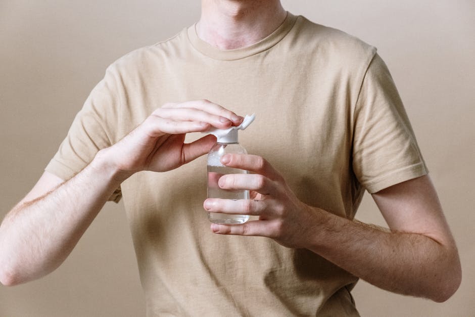 Man in Brown Crew Neck T-shirt Holding Clear Glass Bottle