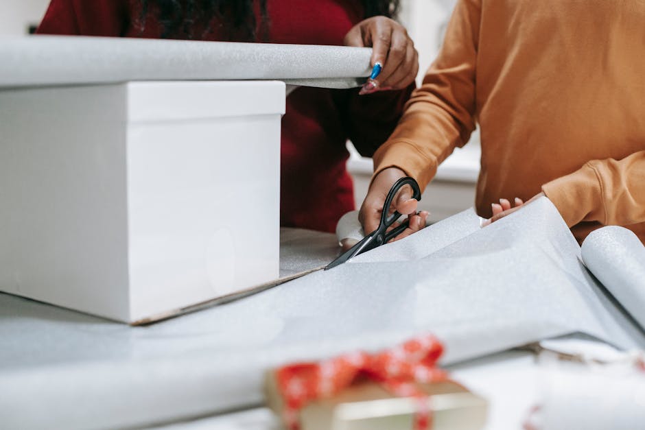 Photo of a Person’s Hands Cutting Wrapping Paper