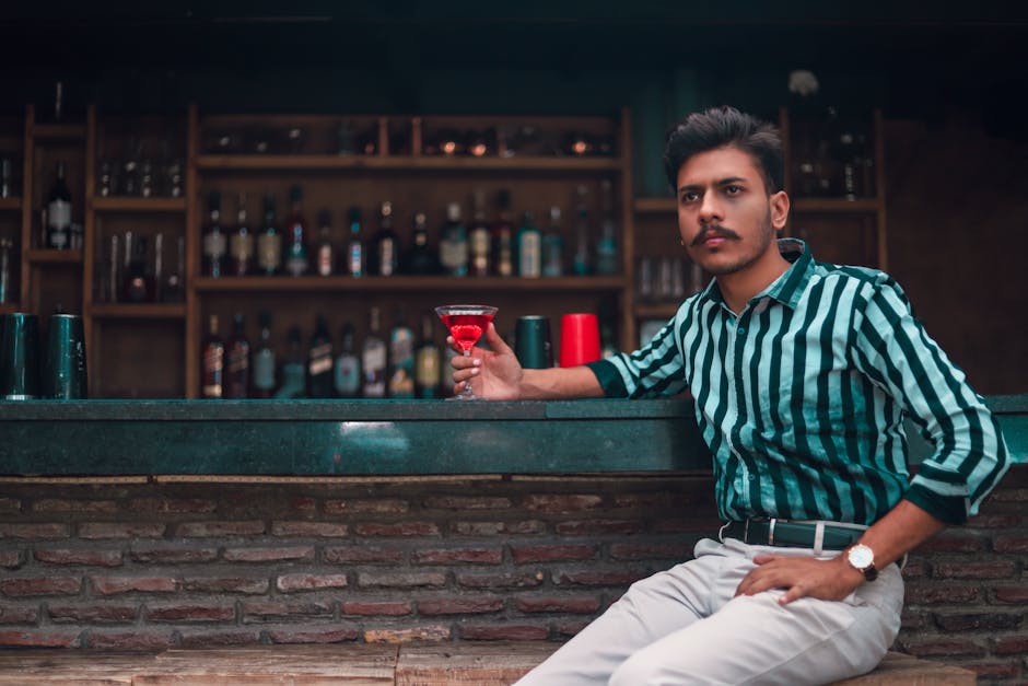 Man Sitting Holding Cocktail Glass