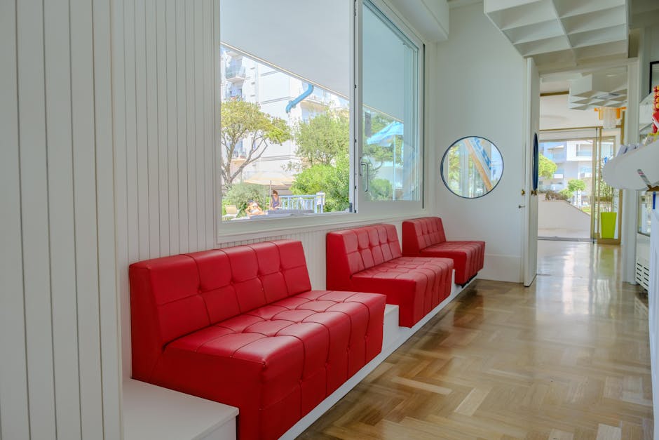 A red couch and white chairs in a hallway