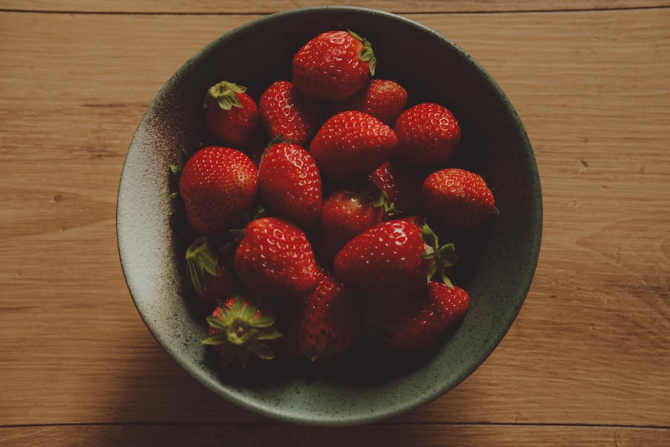 A bowl of strawberries on a wooden table